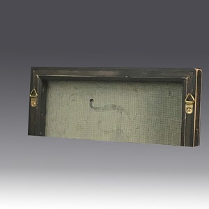 May include: A rectangular wooden frame with a dark finish, featuring a light-colored mesh screen stretched across the center. Two gold-toned triangular metal hanging brackets are attached to the left and right sides of the frame's back edge.