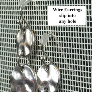 Puede incluir: Pendientes de alambre de plata con m&uacute;ltiples discos redondos texturizados. Los pendientes se muestran sobre un fondo de malla blanca. El texto "Wire Earrings slip into any hole" es visible en la imagen.