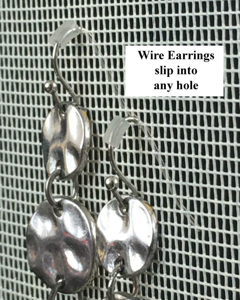 Puede incluir: Pendientes de alambre de plata con m&uacute;ltiples discos redondos texturizados. Los pendientes se muestran sobre un fondo de malla blanca. El texto "Wire Earrings slip into any hole" es visible en la imagen.