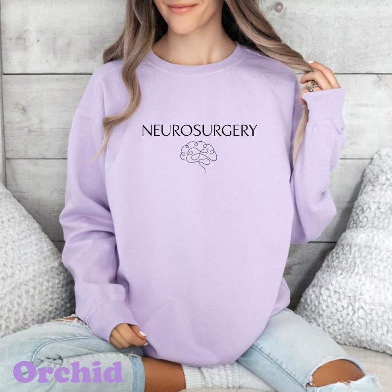 May include: A light purple sweatshirt with the word "NEUROSURGERY" printed in black above a line drawing of a brain. The word "Orchid" is printed in a light purple script at the bottom of the sweatshirt.