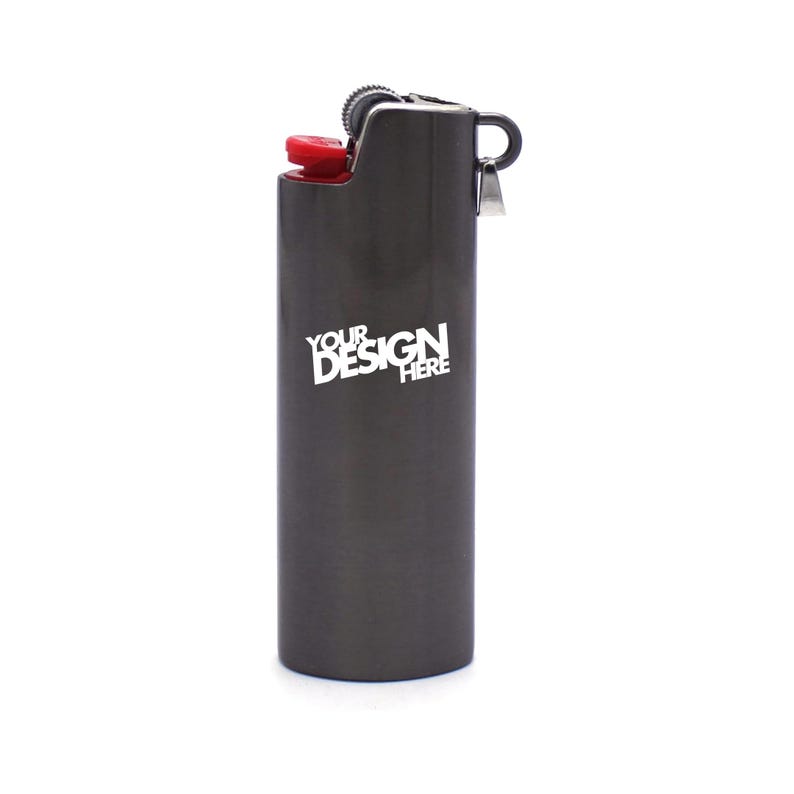 May include: A dark gray lighter with a red ignition button. The lighter has the text "YOUR DESIGN HERE" in white. The lighter is a standard size and shape.