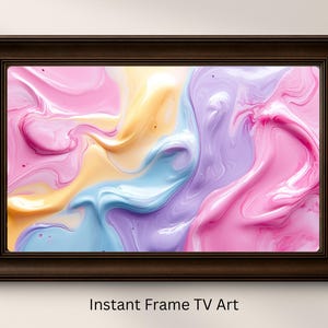 May include: A framed artwork with a swirling abstract design in shades of pink, yellow, blue, and purple. The artwork is in a dark brown frame. The text "Instant Frame TV Art" is at the bottom.