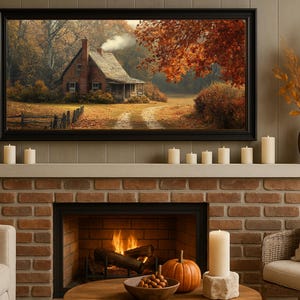 May include: A framed landscape painting of a rustic house with a smoking chimney, set in an autumn scene. The painting hangs above a brick fireplace, with lit candles and a pumpkin. A vase of dried flowers sits nearby.