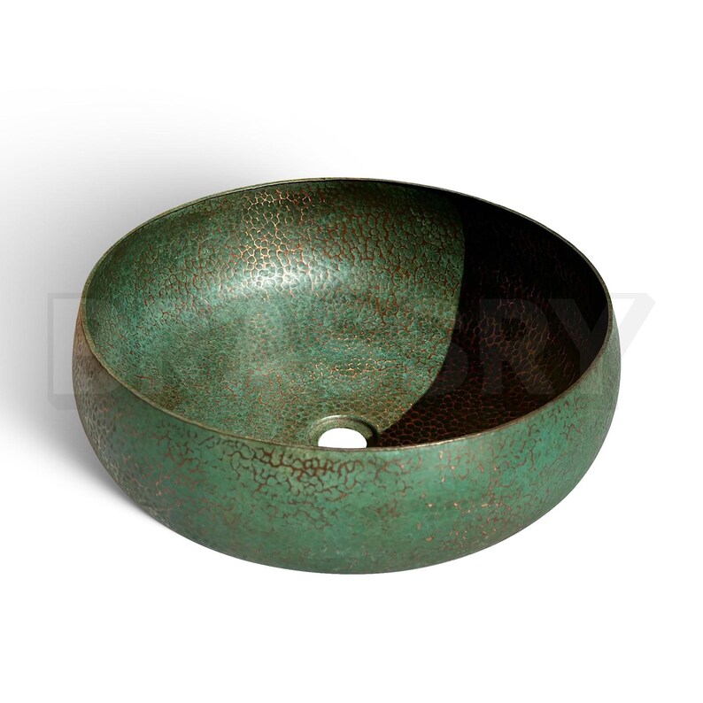 May include: A green and brown ceramic vessel sink with a hammered texture. The sink is round and has a single drain hole in the center.