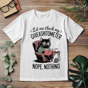 May include: A white ceramic mug with a black handle and the text "But First, Coffee" in a bold, black font. The mug is set against a blurred background, suggesting a cozy setting.