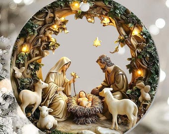 May include: A round Christmas ornament featuring a Nativity scene. The ornament depicts Mary, Joseph, and baby Jesus, surrounded by sheep and set within a tree-like arch. The scene is in shades of gold, cream, and brown, with small lights.
