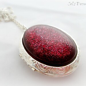 May include: A silver locket necklace with a red glitter filled oval pendant.