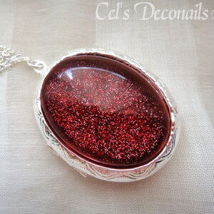 May include: A silver locket necklace with a red glitter filled oval pendant.