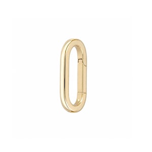 May include: A polished gold-tone oval carabiner clasp with a smooth, reflective surface. The jewelry component features a hinged opening mechanism on one side, allowing it to function as a secure connector for chains, charms, or other accessories.