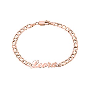 May include: A rose gold chain bracelet with the name "Leora" engraved on it.