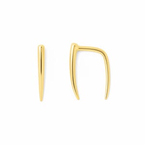 Może przedstawiać: Dwa kolczyki w kolorze złotym. Jeden to prosta, spiczasta sztabka. Drugi ma zakrzywiony, otwarty kształt obręczy. Oba kolczyki mają wypolerowaną, odblaskową powierzchnię i są na białym tle.