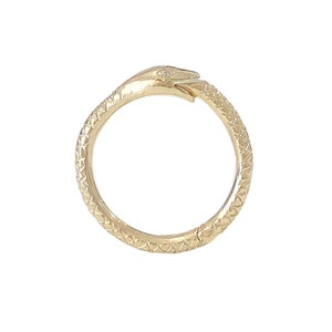 May include: A gold snake ring with a textured surface. The snake's head is curled around the ring.