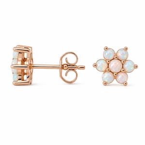 Puede incluir: Pendientes de botón con forma de flor en oro rosa con piedras de ópalo blanco. Los pendientes están diseñados con forma floral, con cada pétalo con un ópalo redondo. Los pendientes se muestran desde múltiples ángulos.