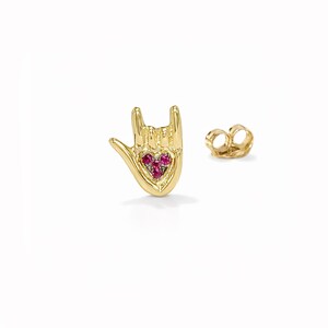 Può includere: Un orecchino a lobo in oro a forma di mano che fa il segno ti amo, con un palmo a forma di cuore incastonato con tre piccole pietre rosse. L'orecchino include una chiusura a farfalla in oro abbinata per un fissaggio sicuro.