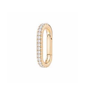May include: An oval-shaped gold carabiner charm featuring a row of small, clear, round-cut stones set along the outer edge. The piece includes a hinged opening mechanism on the side, allowing it to function as a connector for jewelry chains.
