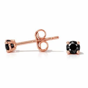 Op de afbeelding: Rosegouden oorstekers met een ronde, zwarte edelsteen. De oorbellen hebben een pin en een vlindersluiting. Eén oorbel wordt in profiel getoond, de andere van voren.