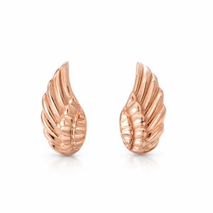 May include: A pair of rose gold-colored wing-shaped earrings. Each earring features detailed feather-like ridges, with a rounded base and a curved, upward sweep. The earrings are displayed against a white background.