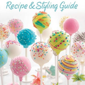 May include: A collection of colorful cake pops on white sticks, decorated with sprinkles, frosting, and various designs. The image includes the text "BEGINNER'S CAKE POP Recipe & Styling Guide" in pink and blue, suggesting a tutorial or guide for making and decorating cake pops.