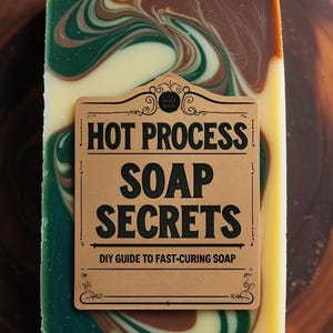 May include: A handmade soap bar with a marbled design in shades of green, brown, and cream. The label reads "HOT PROCESS SOAP SECRETS" and "DIY GUIDE TO FAST-CURING SOAP". The soap is displayed on a wooden surface.
