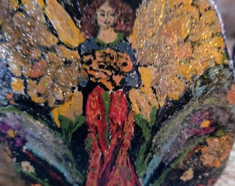 Flor de hadas pintada a mano sobre piedra con pequeño soporte.