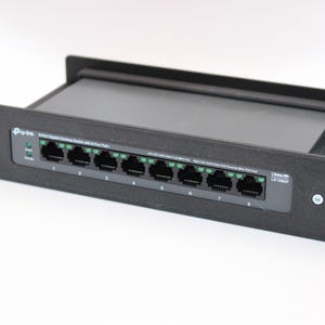 May include: A black 8-port Ethernet switch with a rack mount design. The switch has eight ports with green indicators and the text "Tp-Link" on the front. The model number is LS1008P.