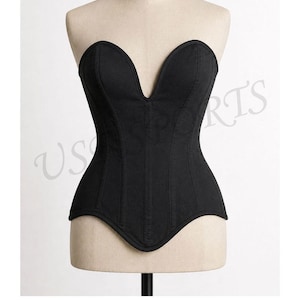 May include: A black strapless corset top featuring a deep V-shaped neckline, vertical seam detailing, and a curved hemline. The garment is displayed on a beige mannequin torso, showcasing a structured fit with a solid black fabric construction.