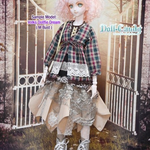 May include: A doll wearing a plaid shirt, a lace skirt, and white boots. The doll has pink hair and is standing in front of a white gate. The text "Doll-Candy" is visible in the upper right corner of the image.