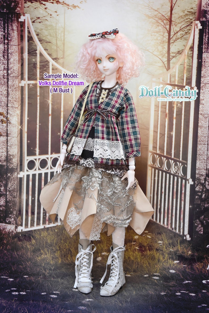 May include: A doll wearing a plaid shirt, a lace skirt, and white boots. The doll has pink hair and is standing in front of a white gate. The text "Doll-Candy" is visible in the upper right corner of the image.