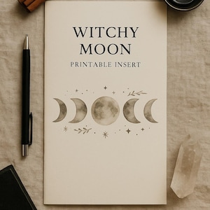 Może przedstawiać: Kremowy, drukowany wkład z czarnymi napisami "Witchy Moon" i "Printable Insert". Wkładka zawiera wzór faz księżyca z gwiazdami i akcentami botanicznymi. Widoczny jest również czarny długopis, kryształ i mała czarna książka.