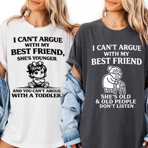 May include: A white t-shirt with black text reading I CAN'T ARGUE WITH MY BEST FRIEND, SHE'S YOUNGER AND YOU CAN'T ARGUE WITH A TODDLER and a graphic of a toddler, and a dark grey t-shirt with white text reading I CAN'T ARGUE WITH MY BEST FRIEND, SHE'S OLD & OLD PEOPLE DON'T LISTEN and a graphic of an elderly person with a walker.