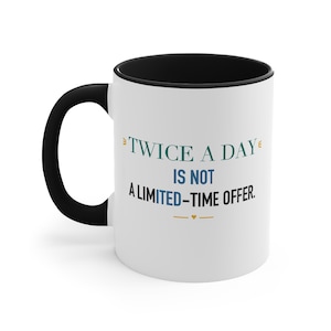 Taza con detalles en negro – Frase divertida sobre la importancia de una taza de café dos veces al día. imagen 1
