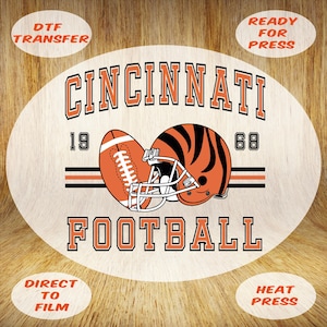 May include: Oval DTF transfer featuring a Cincinnati football design. The design includes a football, helmet, and the words "Cincinnati Football" with the years "19" and "68". The transfer is ready for heat press.