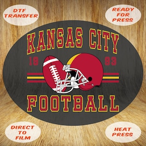 May include: A black oval design featuring a red and yellow football and helmet, with the text "KANSAS CITY FOOTBALL" in yellow. The design includes the numbers "18" and "83". The words "DTF TRANSFER", "READY FOR PRESS", "DIRECT TO FILM", and "HEAT PRESS" are also present.