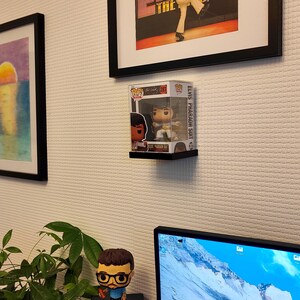 Könnte beinhalten: Eine Funko Pop Vinylfigur von Elvis Presley im Pharaonenanzug, ausgestellt in der Originalverpackung auf einem schwarzen Regal. Die Box ist mit "Elvis Pharaoh Suit" beschriftet. Die Figur ist ein Sammlerstück.