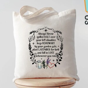May include: A cream-colored tote bag with a black floral design and text. The text reads, "Always throw spilled SALT over your left shoulder, keep ROSEMARY by your garden gate, plant LAVENDER for luck and fall in LOVE whenever you can."