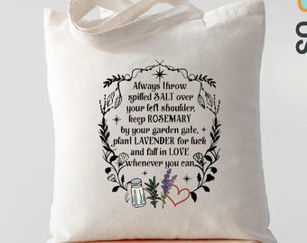 May include: A cream-colored tote bag with a black floral design and text. The text reads, "Always throw spilled SALT over your left shoulder, keep ROSEMARY by your garden gate, plant LAVENDER for luck and fall in LOVE whenever you can."