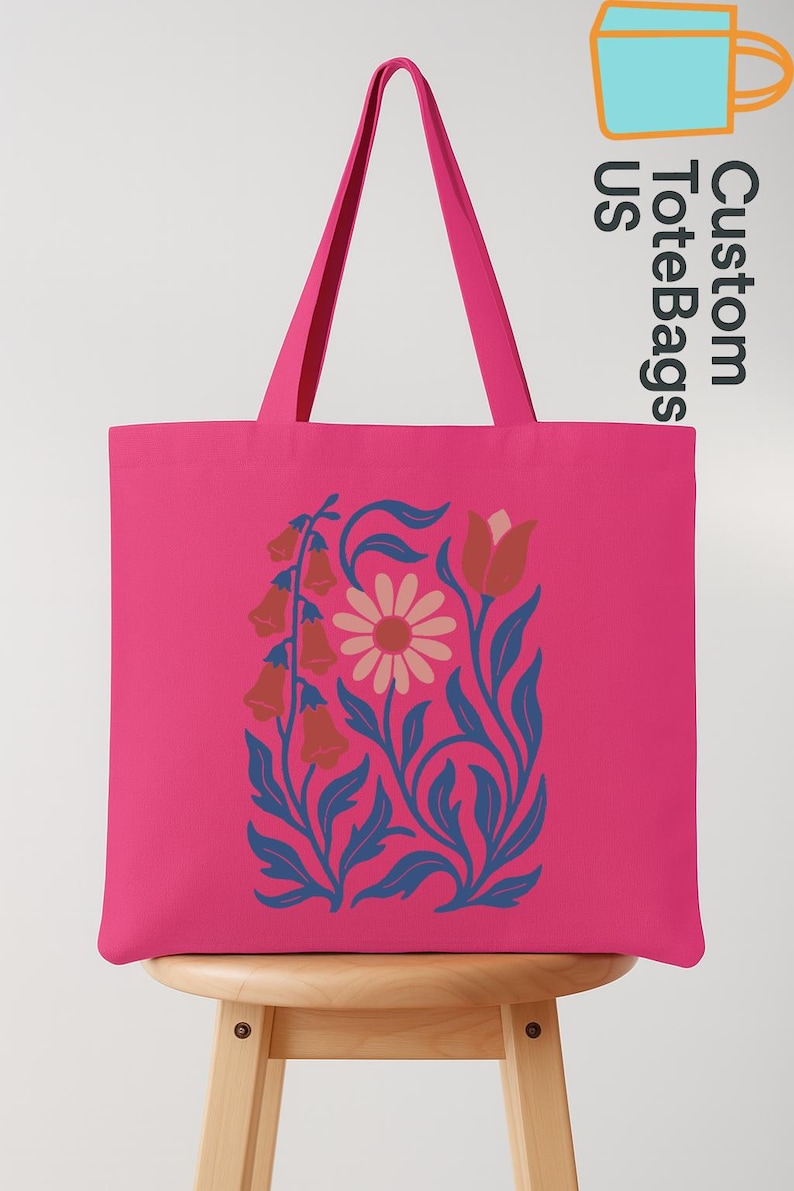 Peut inclure: Un sac fourre-tout rose vif avec un motif floral. Le motif pr&eacute;sente une marguerite, des fleurs en forme de cloche et des feuilles dans des tons orange, bleu et rose. Le sac a de longues anses roses et le texte "Custom Tote Bags US".