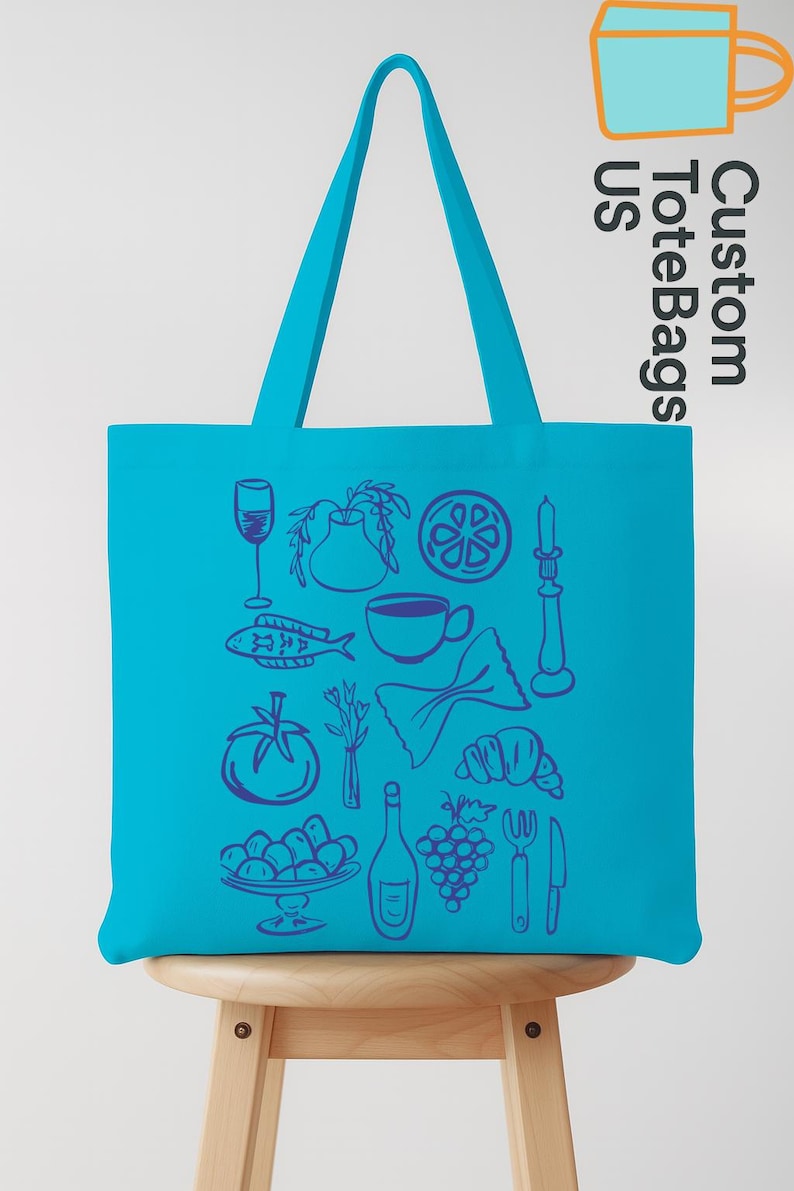 May include: A turquoise tote bag with a variety of food-related illustrations in blue. The bag features images of a wine glass, fish, tomato, pasta, croissant, and a bottle of wine. The text "Custom Tote Bags US" is printed on the side.