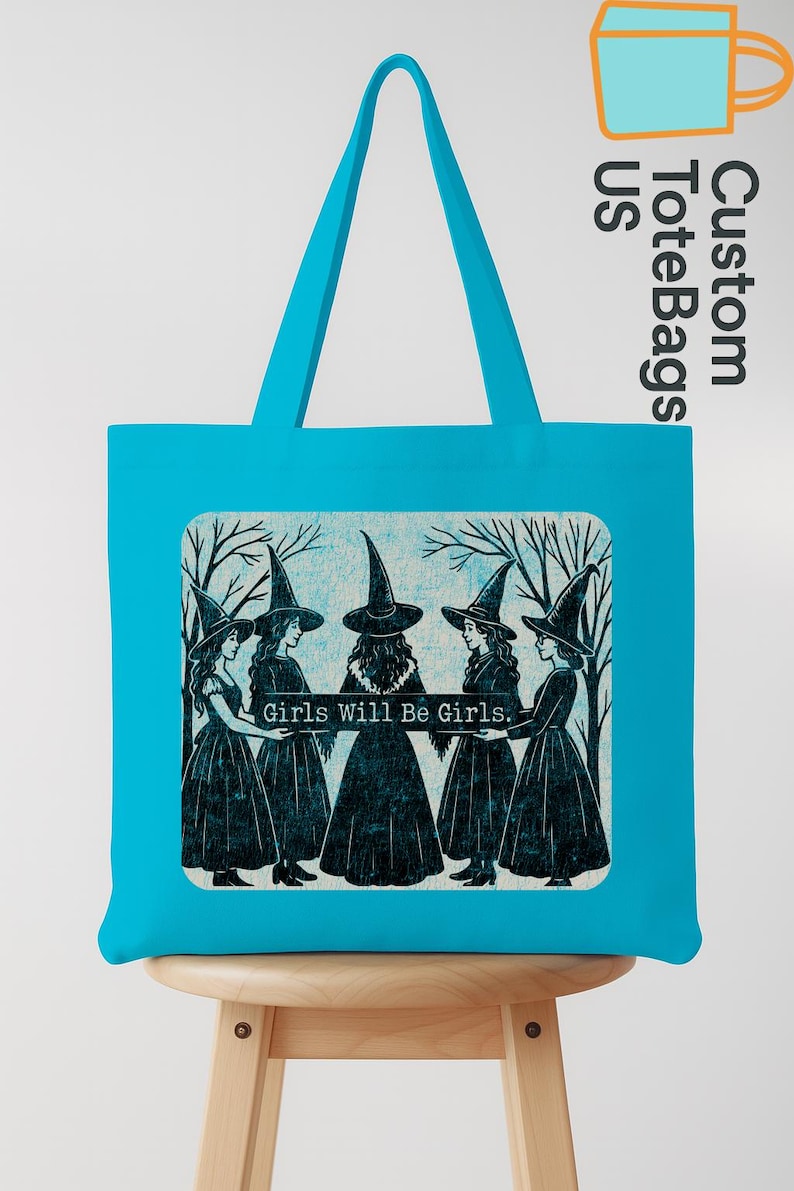 May include: A turquoise tote bag with a graphic of five women in witch hats and dresses, with the text "Girls Will Be Girls." The bag has a rectangular design and a turquoise handle.