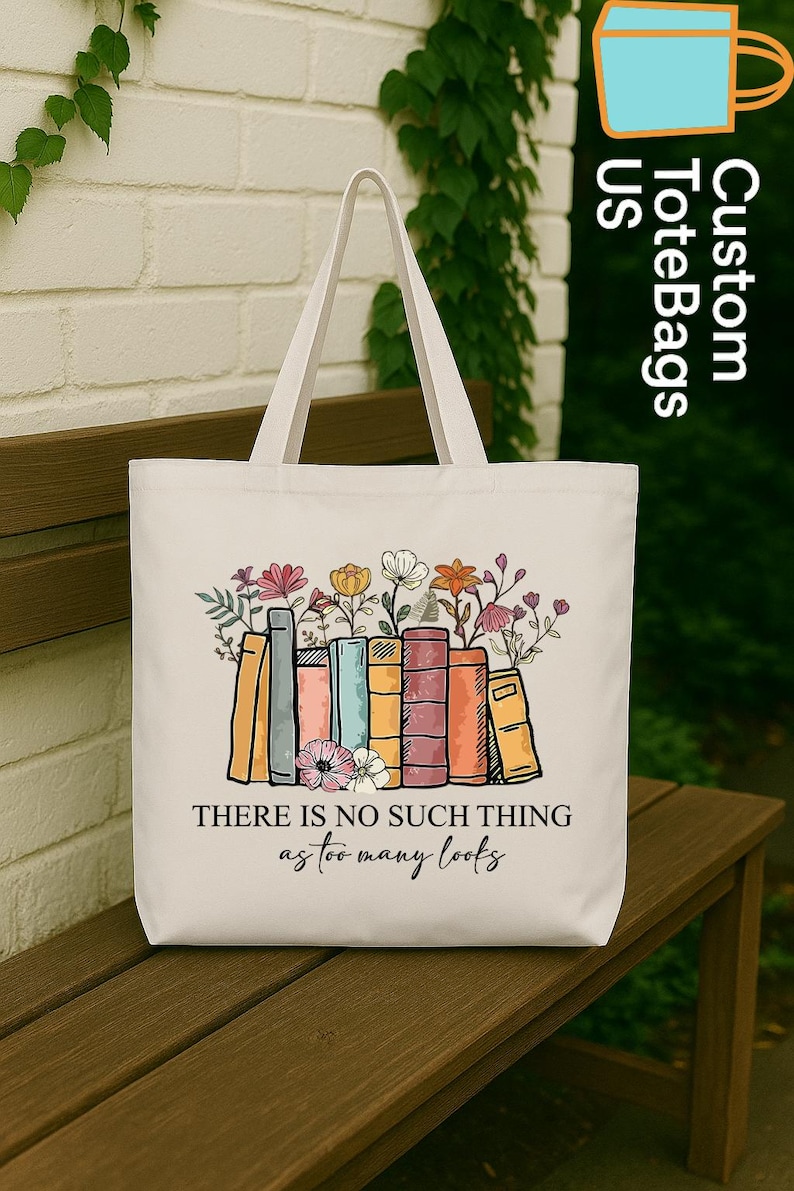 May include: A white tote bag featuring a colorful illustration of books with flowers on top. The text "THERE IS NO SUCH THING as too many books" is printed below the books. The bag has a simple design with two handles.