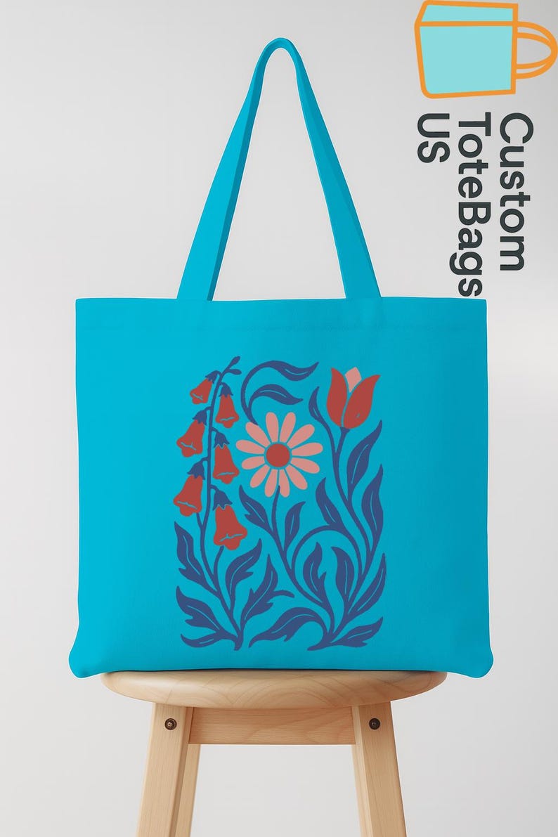 Peut inclure: Un sac fourre-tout turquoise avec un motif floral. Le motif pr&eacute;sente des fleurs rouges en forme de cloche, une marguerite rose et des feuilles et tiges bleues. Le sac a des anses turquoise assorties et le texte "Custom ToteBags US".