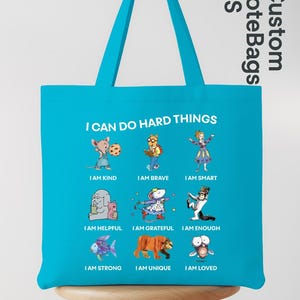 May include: A turquoise tote bag with the text "I CAN DO HARD THINGS" and illustrations of various animals with positive affirmations like "I AM KIND" and "I AM BRAVE". The bag has a matching turquoise handle.