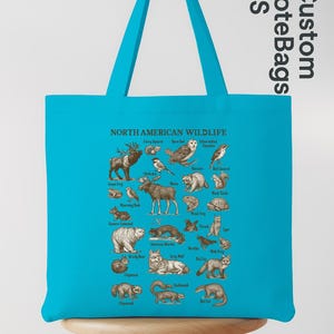 May include: A turquoise tote bag displaying an illustrated guide to North American wildlife. The design showcases animals like a moose, bear, owl, and fox, each labelled. The bag has a matching turquoise handle and the text "Custom Tote Bags US".