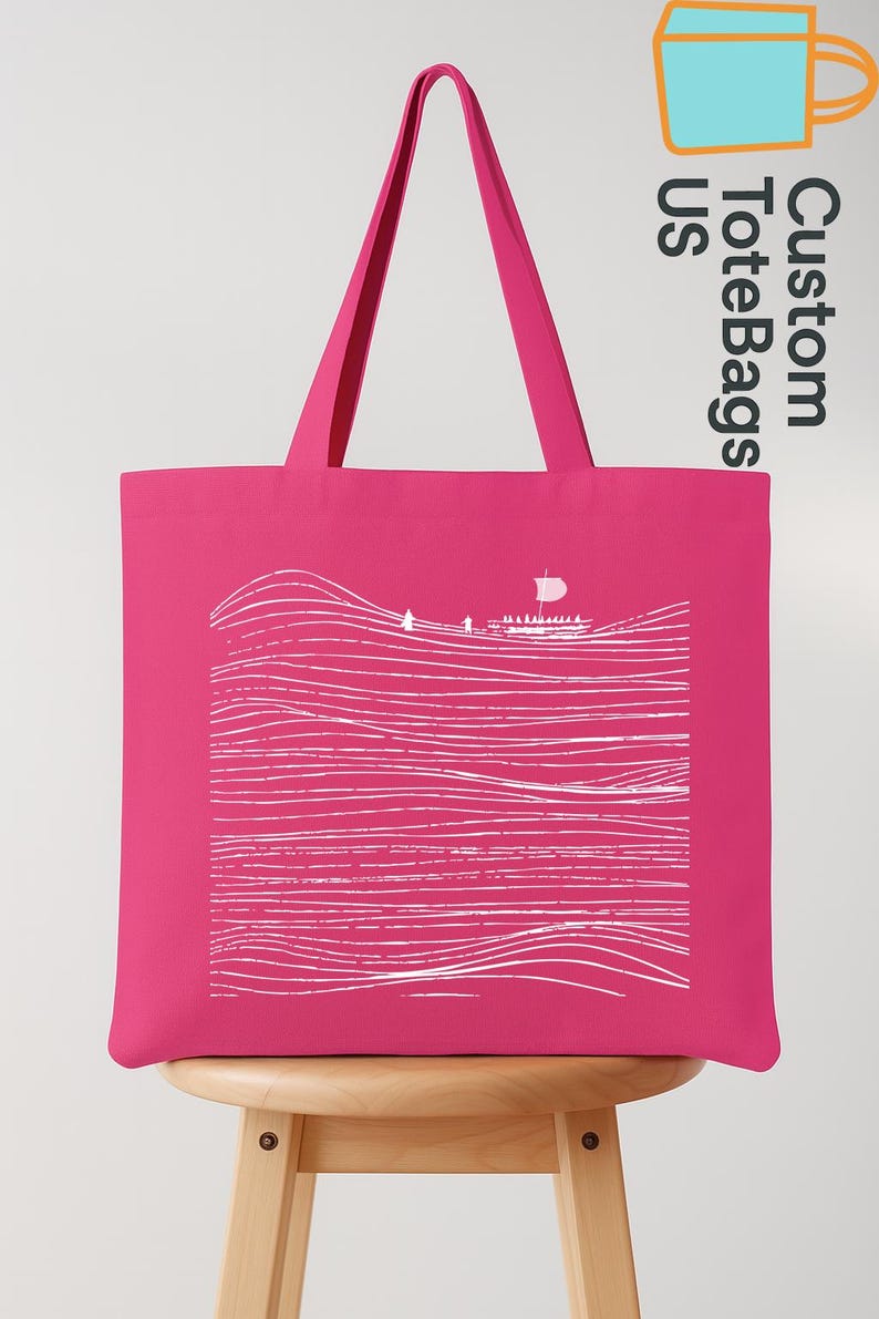 Puede incluir: Un bolso tote rosa brillante con un dibujo lineal blanco que representa un paisaje marino con un velero. El bolso tiene asas rosas a juego y el texto "Custom ToteBags US".