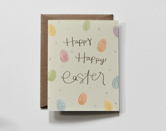 May include: A Happy Easter greeting card with a light green background and colorful watercolor eggs. The card says "Happy Happy Easter" in black cursive writing.