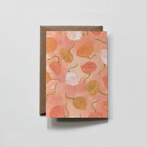 Może przedstawiać: Prostokątna kartka okolicznościowa z powtarzającym się wzorem ręcznie rysowanych róż w odcieniach pomarańczu, brzoskwini i bieli na miękkim, cętkowanym brzoskwiniowym tle, w zestawie z brązową kopertą z papieru pakowego umieszczoną z tyłu.
