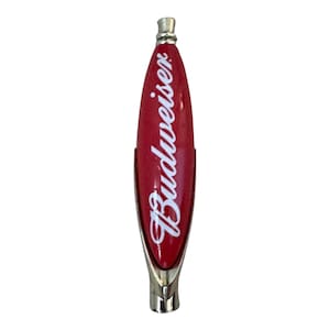 May include: A red Budweiser beer tap handle with a smooth, elongated oval shape and white script lettering. The handle features a metallic silver-colored base and a matching silver-colored top cap, providing a clean and polished appearance.