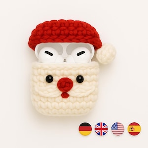 Può includere: Una custodia originale per auricolari wireless, a forma di Babbo Natale. La custodia è realizzata all'uncinetto in filato bianco e rosso, con occhi a bottone neri e un naso rosso. Gli auricolari sono bianchi. Il design è festoso e stravagante.