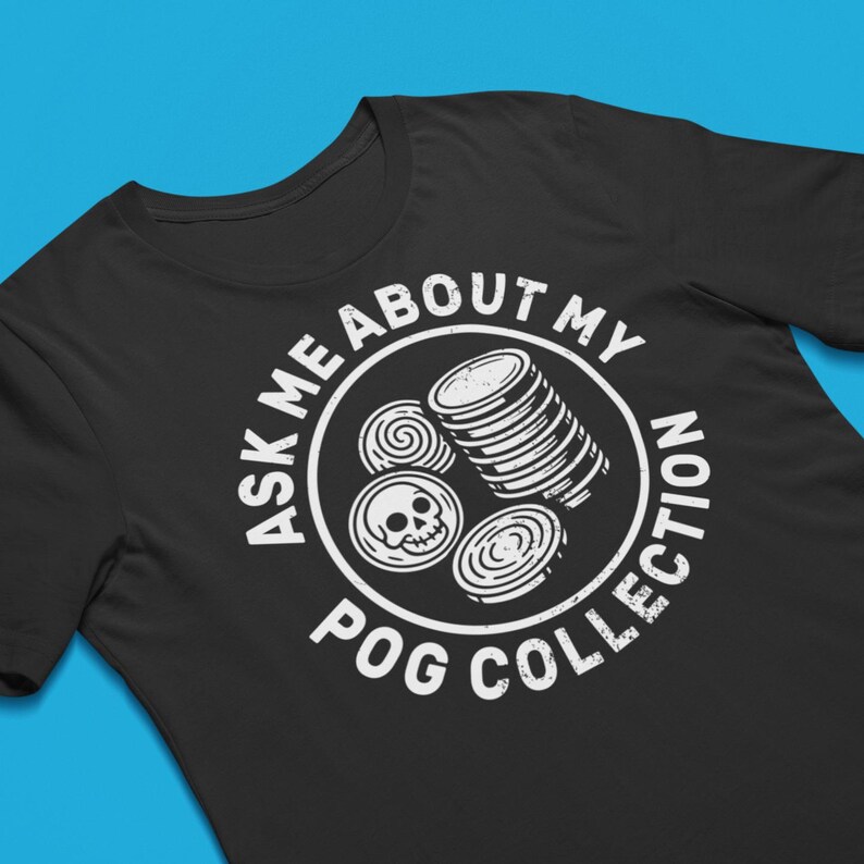 Puede incluir: Camiseta negra con un gr&aacute;fico blanco. El gr&aacute;fico presenta un c&iacute;rculo con el texto "ASK ME ABOUT MY POG COLLECTION". Dentro del c&iacute;rculo hay im&aacute;genes de pogs, incluyendo una pila y un pog de calavera.