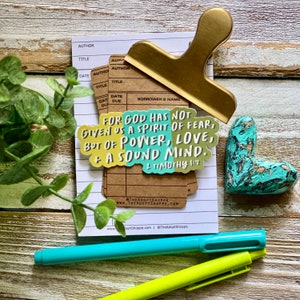 Può includere: Un adesivo con sfondo giallo, verde e blu con il testo "Poiché Dio non ci ha dato uno spirito di timidezza, ma di potenza, di amore e di autocontrollo. 2 Timoteo 1:7".